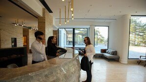A reception area with a marble counter, a sofa, and a large window offering a view of the outdoors. - Amorium Hotel (Kastamonu)