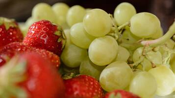 A close-up of a fruit bowl containing strawberries and green grapes.