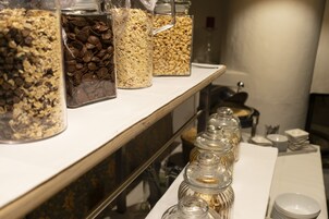 Una mesa de buffet con diversos alimentos en recipientes de vidrio.