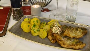 A plate of food with potatoes and fish on a table.