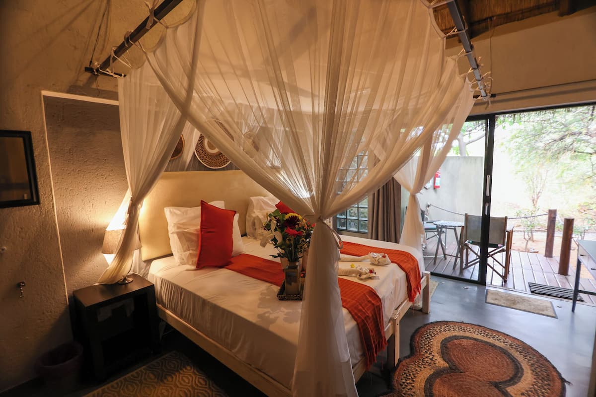 A bedroom with a bed, bedside table, and a window.