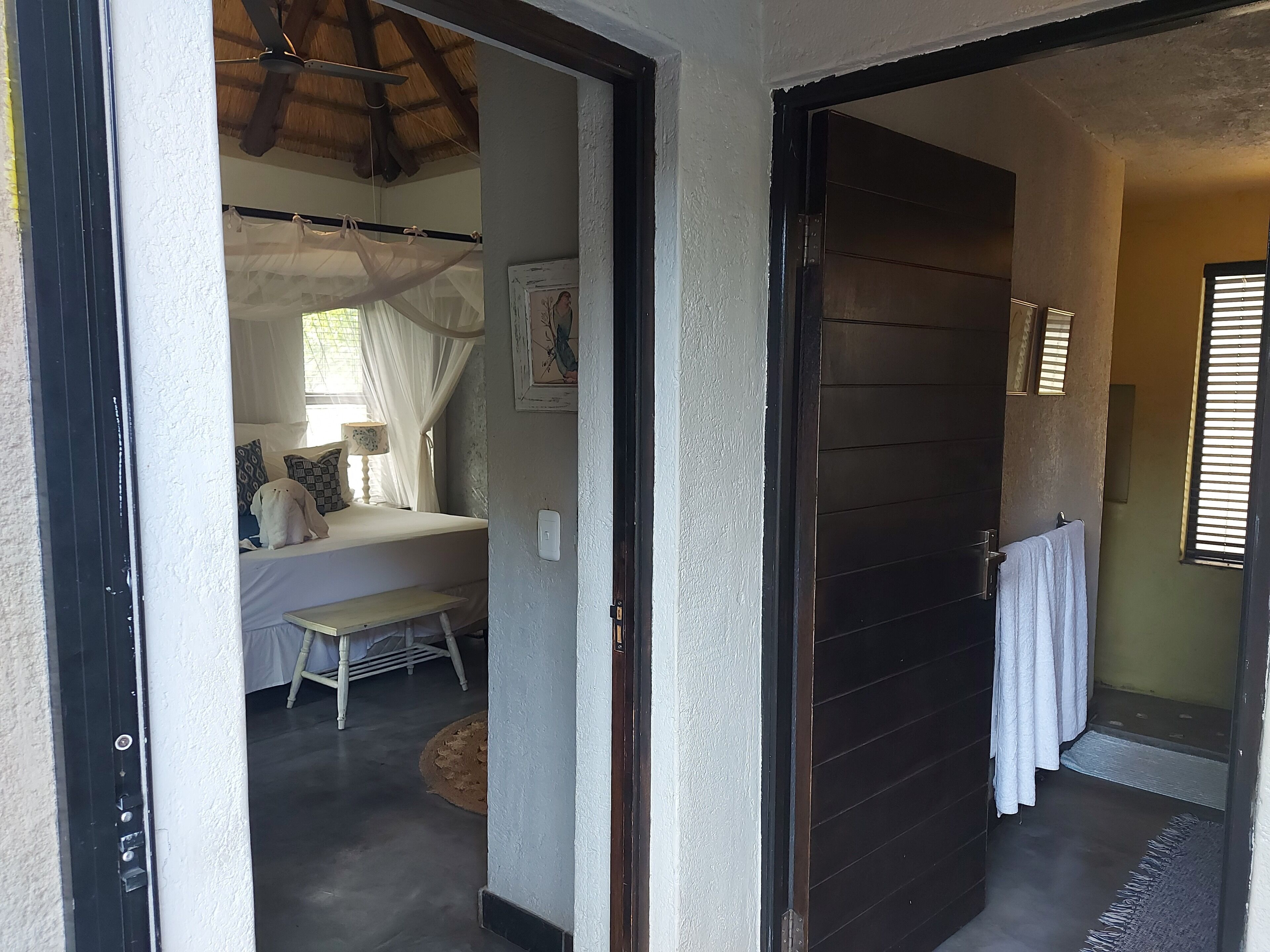 Ein Schlafzimmer mit Bett, Nachttisch und einem Vorhangfenster.