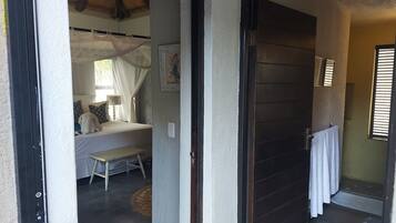 Ein Schlafzimmer mit Bett, Nachttisch und einem Vorhangfenster.