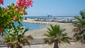 A marina with boats, a sandy beach, and palm trees. - Saint Joseph Resort (Salerno)