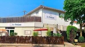 Un bâtiment à deux étages sur lequel on peut lire l’inscription « Le Boisate ».