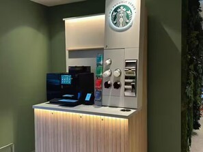 A Starbucks coffee shop counter with a digital ordering kiosk and a coffee machine. - Nordseka hotel The Hague Voorburg (Voorburg)