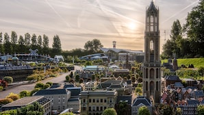 A historic town square with a prominent church tower, traditional buildings, and a modern structure with a glass roof. - Nordseka hotel The Hague Voorburg (Voorburg)