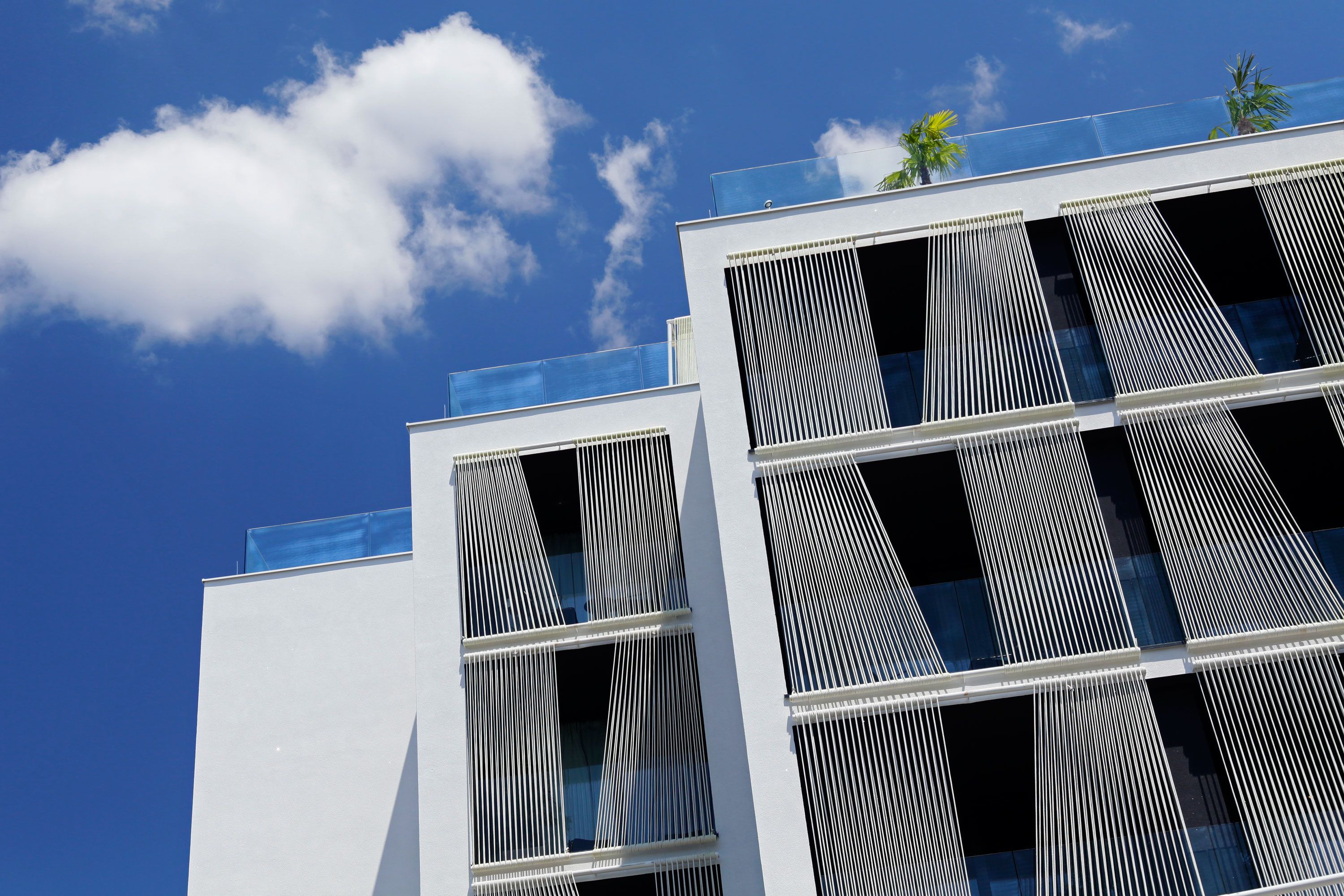 A modern building with large windows and a clear blue sky.