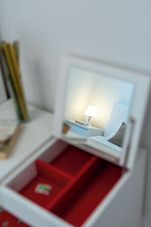 A miniature model of a hotel room with a bed, nightstand, lamp, and a red interior. - Villa Eight by A (Okrug)