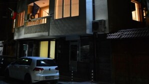 A multi-story building with illuminated windows and a car parked in front. - Bon Bon Hotel (Sofia)