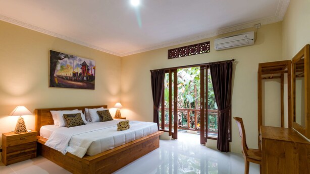 A bedroom with a wooden bed, nightstands, a desk, and a large window with curtains. - Alam Pangkung Ubud (Ubud)