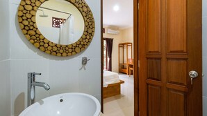 A bathroom with a round mirror, a sink, and a shower. - Alam Pangkung Ubud (Ubud)