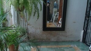 A tiled floor with a geometric pattern, a potted plant, and a framed mirror on the wall.