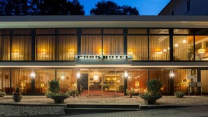 Un hotel con fachada moderna, ventanas grandes y un letrero que dice 'Park Hotel'.