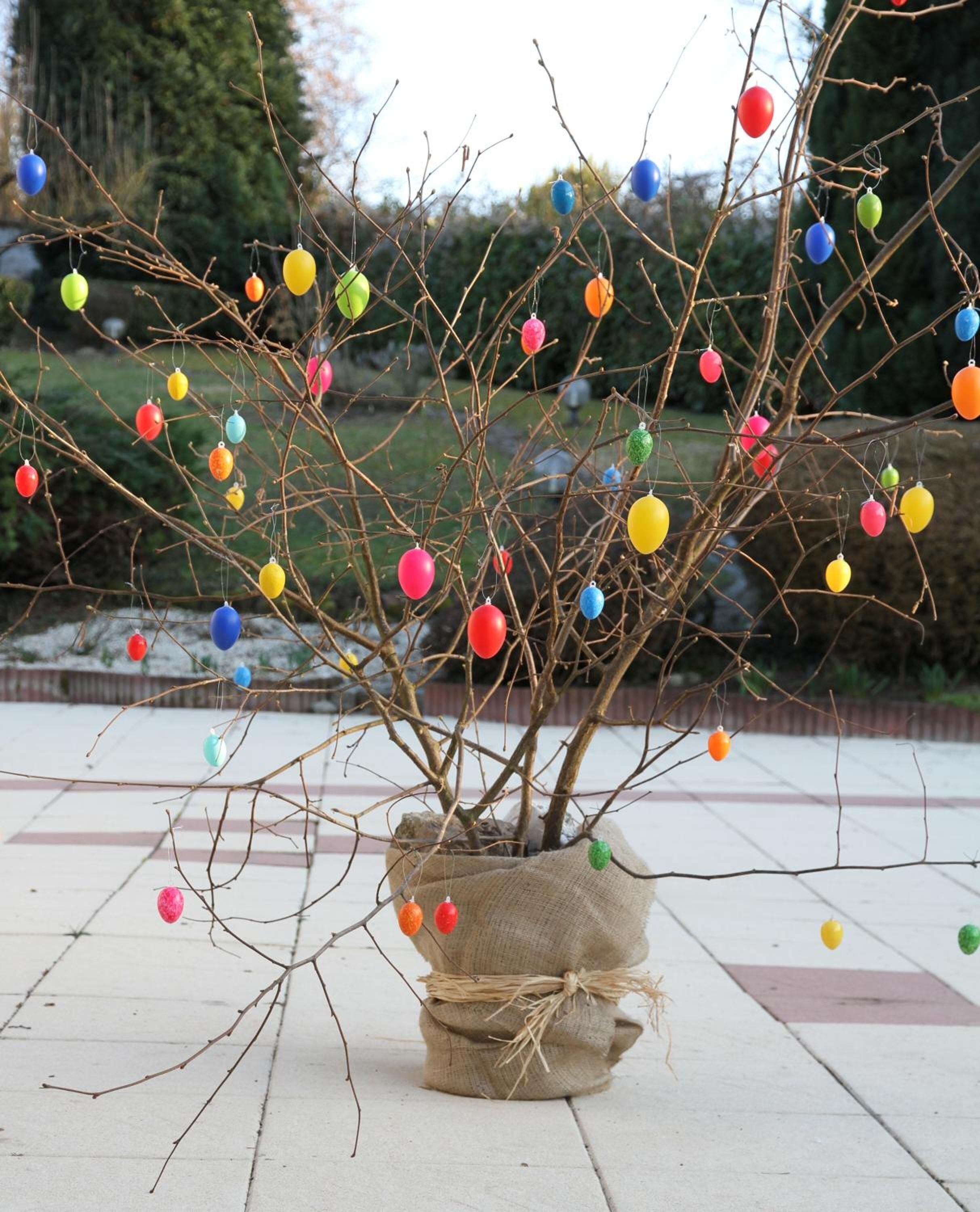 A potted plant with colorful ornaments on its branches.