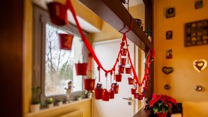A room with a window, a radiator, a wooden bench, and a wall with heart-shaped decorations. - La Rose Tremiere (Wintzenheim-Kochersberg)