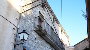 A stone building with a balcony, a lantern, and an archway.
