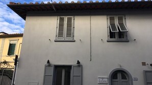 A two-story building with a white facade, two windows with shutters, a central door, and a small sign above the door. - B&B Le Casine di Firenze (Florence)
