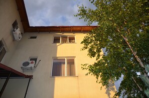 A building with two windows and an air conditioning unit on the wall. - Club-Hotel Flagman (Bishkek)