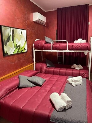 A bunk bed room with a red wall, a painting of flowers, and a red curtain. - La Casa di Chiaretta (Falerna)