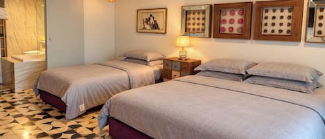 Habitación de hotel con dos camas, baño y piso estampado.