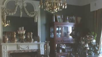 Une salle à manger agrémentée d’un lustre, d’une cheminée et d’un buffet aux portes vitrées.