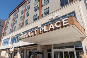 A multi-story hotel with a sign reading "Hyatt Place" and "Regis" above it.