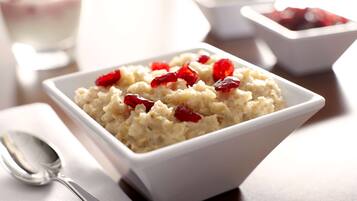 A bowl of oatmeal with red berries.