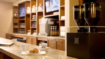 Una encimera de cocina con una cafetera, un tazón de cereal y una taza de café.