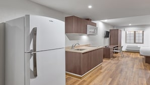 Una cocina compacta con un refrigerador blanco, armarios de madera, un microondas integrado y una ventana con vistas.
