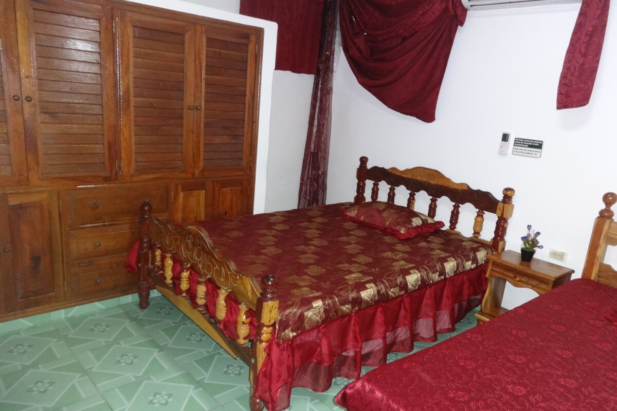 Une chambre à coucher avec un lit en bois, une armoire en bois et une petite table de chevet.