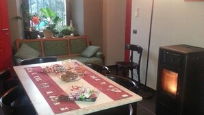 A dining area with a table set for a meal, a fireplace, and a window with plants.