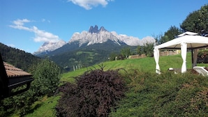 Un mirador en un paisaje verde exuberante, con una montaña al fondo.
