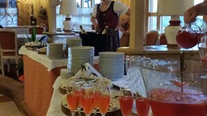 Montaje de bufé con aperitivos de mariscos, una estación de bebidas y una persona sirviendo.