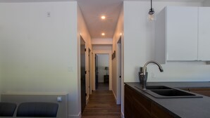 A modern kitchen with a wooden floor, a built-in sink, and a countertop. - The Burfield (Sun Peaks)