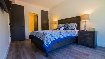 Quarto com cama, mesas de cabeceira e guarda-roupa.