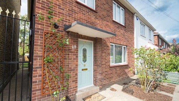 A two-story brick house with a white door and a small garden area. - TDM Bachelot Lettings (London)