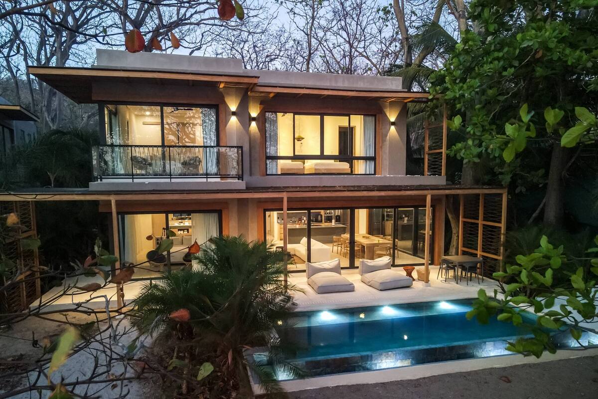 Een modern herenhuis met zwembad, grote ramen en terras.