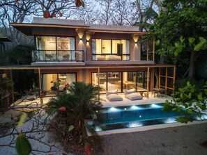 Een modern herenhuis met zwembad, grote ramen en terras.