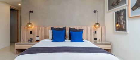 Un dormitorio moderno con una cama grande, dos mesitas de noche y un cabecero de madera.