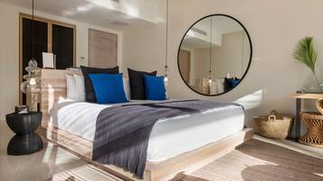 A modern bedroom with a wooden bed, a large round mirror, and a bedside table with a lamp.