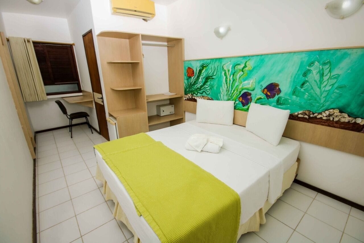 Una habitación de hotel con una cama, un escritorio y un armario.