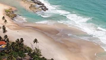 En la playa, arena blanca, toallas de playa, 2 bares en la playa