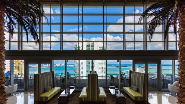 A spacious lobby with large windows offering a view of the ocean and city skyline. - 1 Bedroom Brickell Condo (Miami)