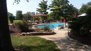 A swimming pool area with a gazebo, surrounded by trees and a grassy lawn. - Shane Acres Country Inn (Juneau)