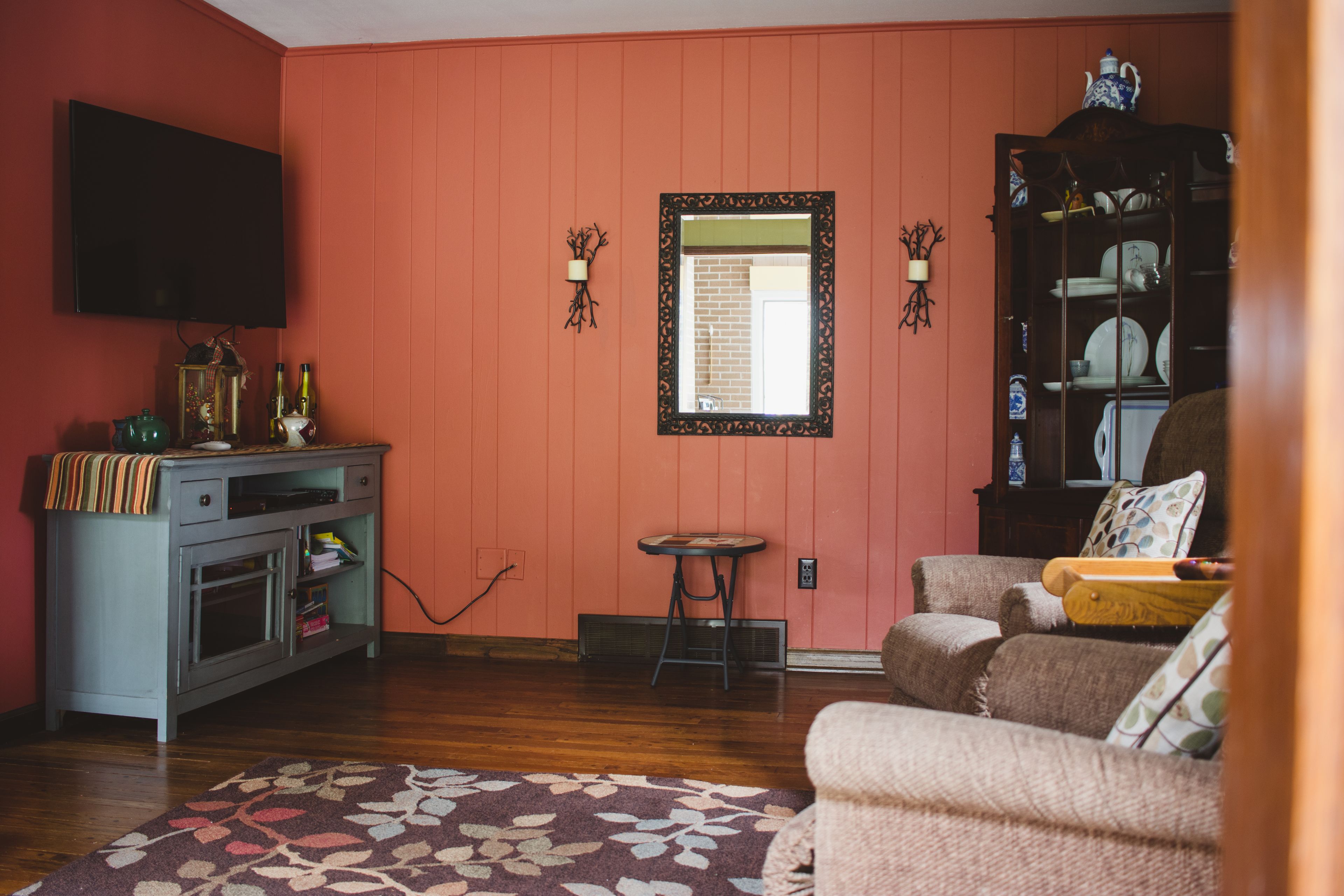 A living room with a television, a cabinet, a small table, and a sofa.