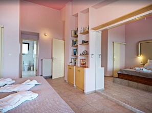 A hotel room with a bed, a bathroom, and a small kitchenette.