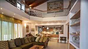 A spacious living area with a sofa, coffee table, and a kitchen in the background. - Halepa Hill (Rethymno)