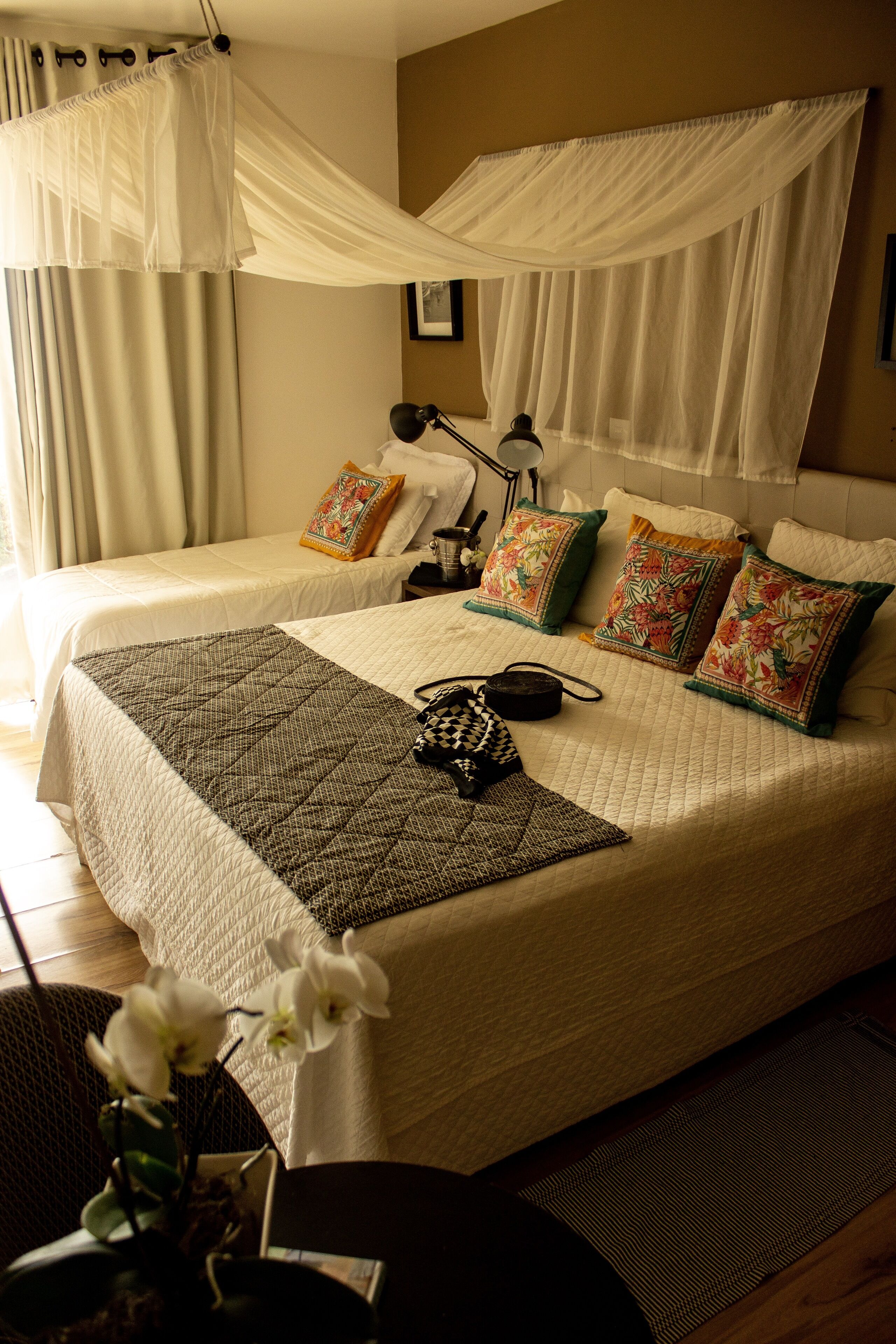 A neatly arranged bedroom with a large bed, two pillows, a bedside lamp, and a decorative item on the bed.