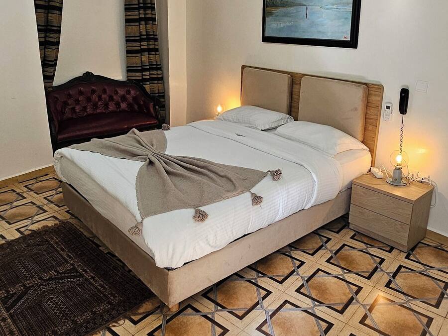 Un dormitorio con cama, mesita de noche y aire acondicionado de pared.